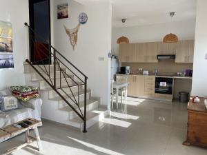 a living room with a staircase and a kitchen at Two bedroom Duplex :Mountain and Sea view in Larnaca
