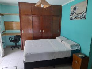 1 dormitorio con 1 cama y armario de madera en Casa cerca del microcentro y costanera en Posadas