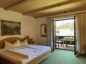 a bedroom with a bed and a door to a balcony at Haus Lukaswinkl in Schönau am Königssee
