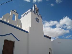uma igreja branca com um relógio ao lado em Casa da Estalagem - Turismo Rural em Ervidel