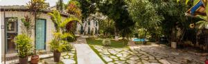 un jardín con árboles y un edificio y un edificio en Pousada Villa Bia, en Pirenópolis