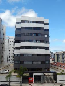 um alto edifício preto e branco numa cidade em Ametista Flat em Maceió