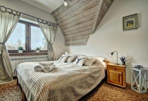 a bedroom with a large bed with a wooden ceiling at Willa Weronika in Zakopane