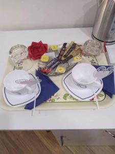 a table with two white plates and glasses on it at Luxury Apartment at Pirosmani 22 in central Borjomi in Borjomi