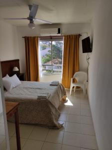 1 dormitorio con cama y ventana en Hosteria Ymaz en Villa Gesell