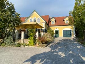 una casa amarilla con puerta y entrada en Landcafe Auszeit en Albersdorf
