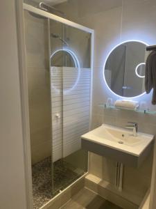 W łazience znajduje się umywalka oraz prysznic z lustrem. w obiekcie Hôtel Saint Pierre w Paryżu