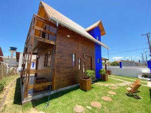 ein kleines Holzhaus mit Schaukel in der Unterkunft Cabana do Embaú Experience in Palhoça