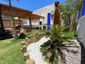 a garden with a palm tree and a wooden fence at Cabana do Embaú Experience in Palhoça