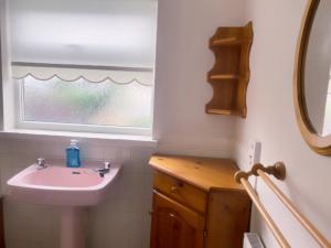 ein Badezimmer mit Waschbecken und Fenster in der Unterkunft Bexleyhealth Town Center 5 Bedroom Luxurious Home in Bexleyheath + 21 Fotos