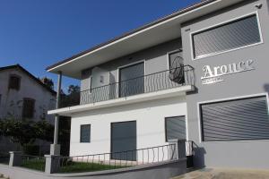 un edificio bianco con balconi e un cartello sopra di ArouceHostel a Lousã