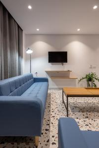 a living room with a blue couch and a table at Studio Apartments 365 in Tirana