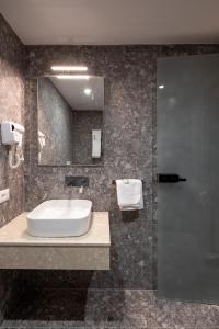 uma casa de banho com um lavatório e um espelho em Spa & Pool - Studio Apartments 365 em Tirana