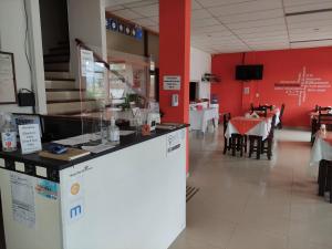 a restaurant with a counter and a table and chairs at Hosteria Ymaz in Villa Gesell