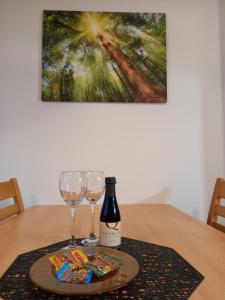 a bottle of wine and two glasses on a table at Apartma Happy in Kranjska Gora