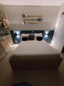 1 dormitorio con 1 cama grande y 2 almohadas en Flat Amarilis Apartamento 103 en Riviera de São Lourenço