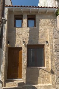 a building with a brown door and three windows at Braos Villa in Khóra Sfakíon