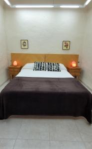 een slaapkamer met een groot bed met 2 verlichting bij ALOJAMIENTO RURAL LOS MOLINOS in Gátova