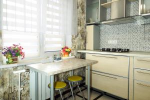 a kitchen with a counter and stools in it at 2 Rooms Semi-luxury Apt on 39-H Nezalezhnoi Ukrаiny Street next to the city council (Walk of Fame) in Zaporozhye