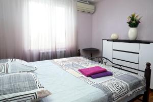 a bedroom with a bed with a purple pillow on it at 2 Rooms Semi-luxury Apt on 39-H Nezalezhnoi Ukrаiny Street next to the city council (Walk of Fame) in Zaporozhye
