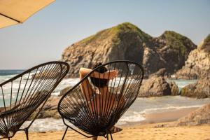 una persona sentada en una silla en una playa en Hotel Noga, en Zipolite