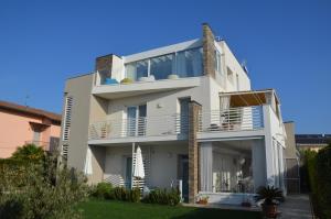 ein weißes Haus mit Balkon und Hof in der Unterkunft Lugana 9 in Peschiera del Garda