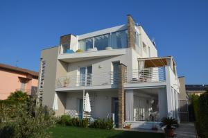 a white house with balconies and a yard at Lugana 9 in Peschiera del Garda