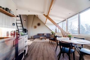 a kitchen and living room with a table and chairs at Spacious Luxury Loft in Zandvoort