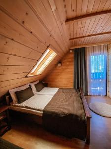 a large bed in a wooden room with a window at U Maćka in Białka Tatrzańska