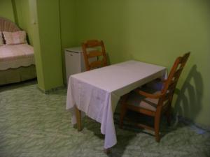 a room with a table and chairs and a bed at Pavillon Des Receptions & Hotel in Port-au-Prince
