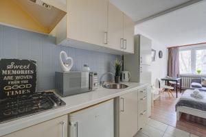 a kitchen with a sink and a stove top oven at Noctis Apartment Bagno in Warsaw
