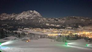 a town in the snow at night with a mountain w obiekcie Hochfeldalm w mieście Sankt Johann in Tirol