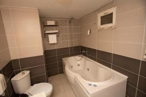 a bathroom with a toilet and a bath tub at SRF Hotel in Eskisehir
