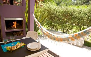 un hamac sur une terrasse avec une table et une cheminée dans l'établissement Casaplaya, à Las Gaviotas