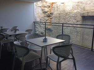 a dining room with tables and chairs and a wall at Casa Dona Maria Luiza in Torre de Moncorvo