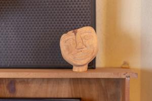 una máscara de madera sentada en la parte superior de un estante en Ladiri - Antica dimora in terra cruda, en Sinnai