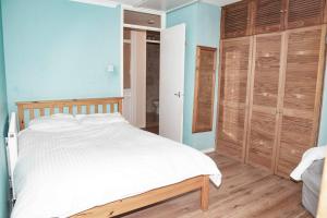 劍橋的住宿－Spacious 1bed flat in Cambridge near Chesterton，卧室配有白色的床和木制橱柜。