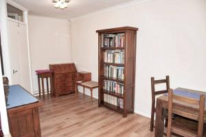 a living room with a book shelf with books at Spacious 1bed flat in Cambridge near Chesterton in Cambridge