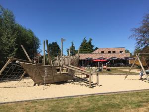 a playground with a wooden slide in a park at Barbos in Lembeke
