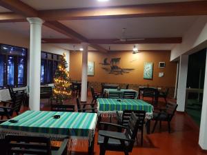 a dining room with two tables and a christmas tree at Guesthouse Panorama in Beruwala