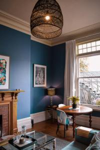a living room with blue walls and a table at The Vicarage Boutique Bed and Breakfast Oamaru in Oamaru