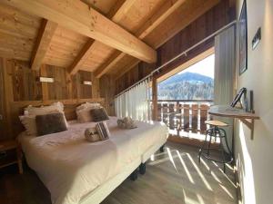 a bedroom with a bed and a large window at Chalet Azalée, Montriond, Morzine, Avoriaz in Montriond