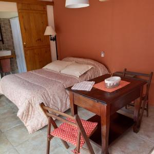 a bedroom with a bed and a table with at Monoambiente en Colonia in Colonia del Sacramento