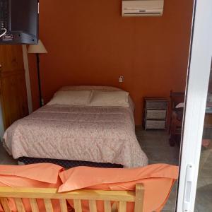 a small bedroom with a bed and a television at Monoambiente en Colonia in Colonia del Sacramento