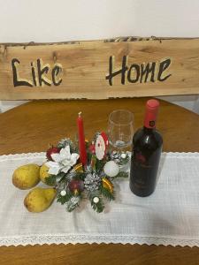una bottiglia di vino e della frutta sul tavolo di LIKE HOME a Rîşnov