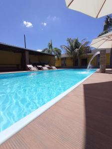 une piscine avec des chaises et un bâtiment dans l'établissement Hotel Imperial, à Mundo Novo