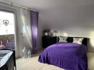 a bedroom with a purple bed and a window at Ferienwohnung Pension Am Berg in Villingen-Schwenningen