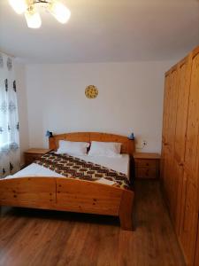 um quarto com uma grande cama de madeira e pisos de madeira em Pensiunea Aryana em Crasna din Deal