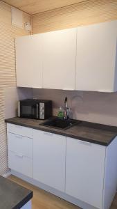 uma cozinha com armários brancos e um micro-ondas em Myplace in Oulu Studio Koulukatu em Oulu