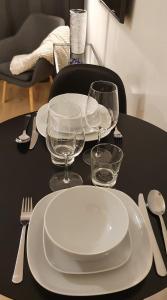 a black table with white plates and glasses on it at Myplace in Oulu Studio Koulukatu in Oulu